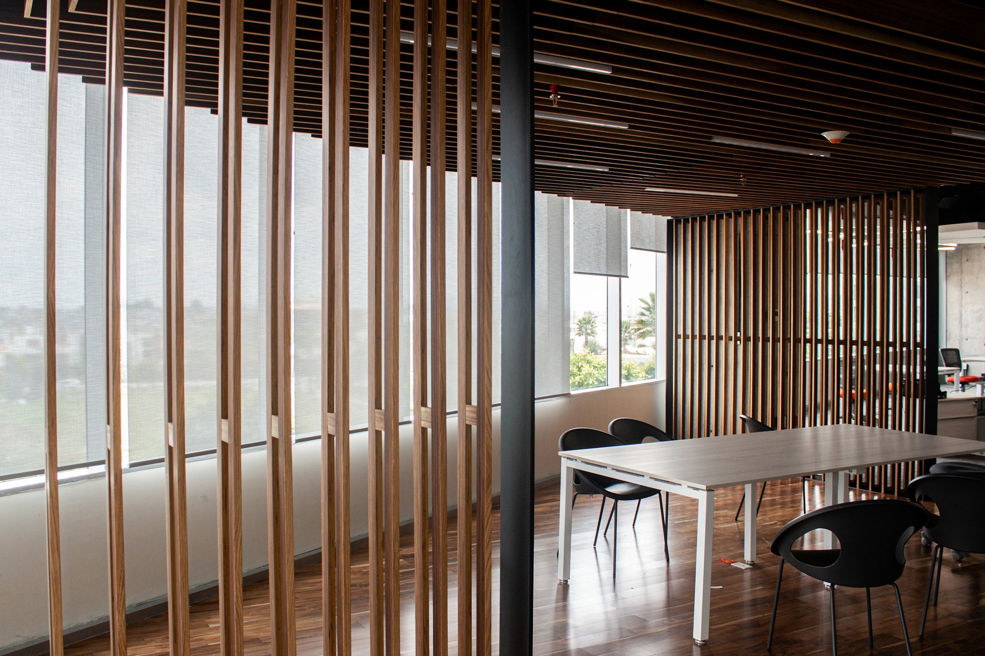 Celosía de listones verticales separando una sala de reuniones